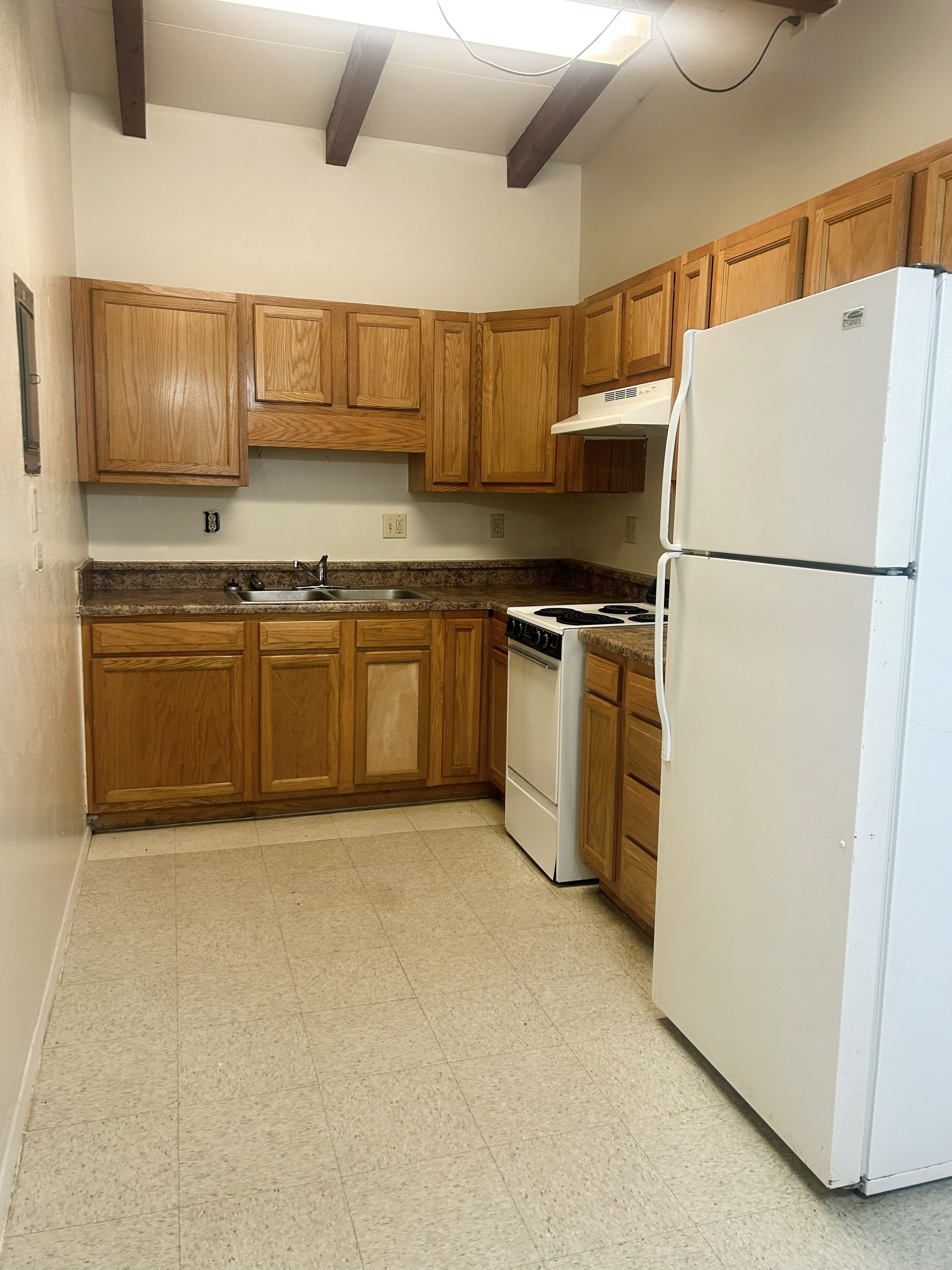 705 Bursum kitchen with wood cabinets, exposed beam ceiling and appliances